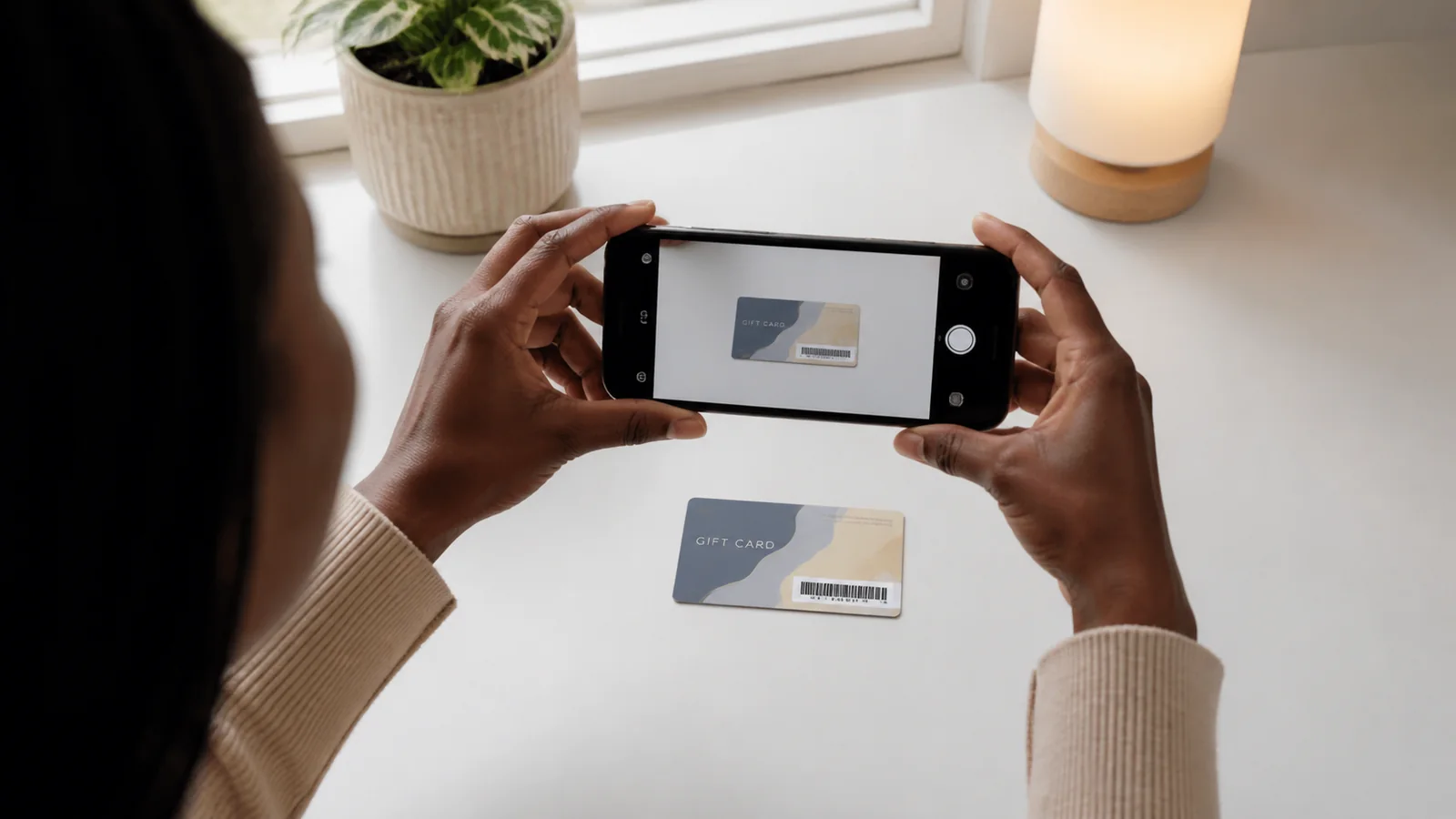Black customer photographing a full gift card clearly in soft even light